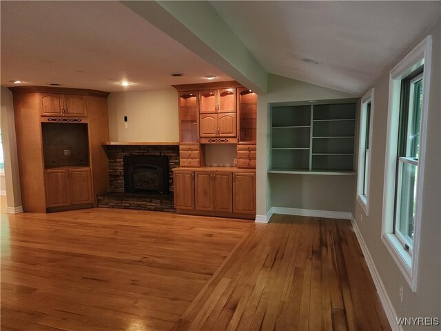 6731 Chestnut Ridge Rd, Orchard Park, NY 14127 - unfurnished living room featuring light wood-style floors, vaulted ceiling, a stone fireplace, baseboards, and recessed lighting