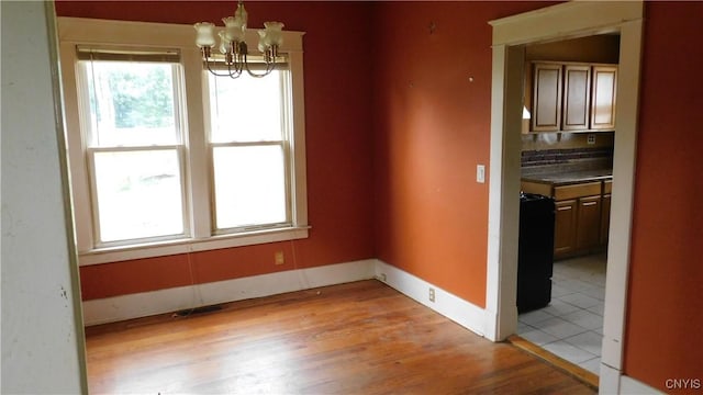409 E Bloomfield St, Rome-Inside, NY 13440 - unfurnished dining area with a chandelier, light wood-style flooring, and baseboards