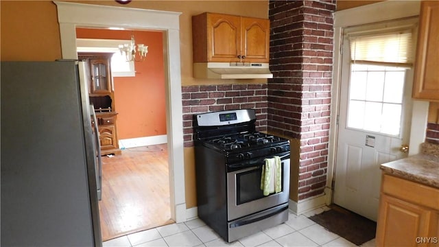 409 E Bloomfield St, Rome-Inside, NY 13440 - kitchen featuring appliances with stainless steel finishes, under cabinet range hood, a chandelier, light tile patterned flooring, and baseboards