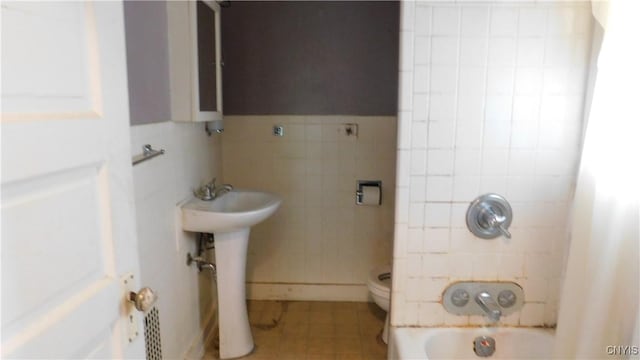409 E Bloomfield St, Rome-Inside, NY 13440 - full bath featuring tile patterned floors, tile walls, a sink,  shower combination, and toilet