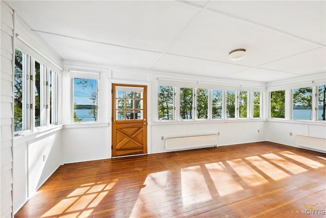5199 W Lake Rd, Fleming, NY 13021 - unfurnished sunroom featuring radiator, plenty of natural light, and hardwood / wood-style floors