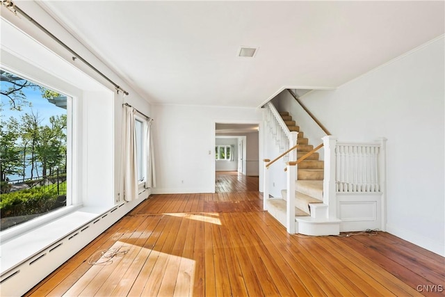 5199 W Lake Rd, Fleming, NY 13021 - unfurnished living room with healthy amount of natural light, a baseboard heating unit, and light wood-style flooring