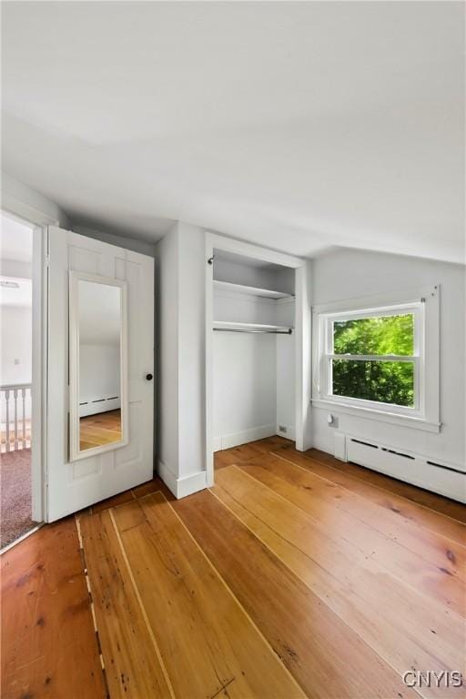 5199 W Lake Rd, Fleming, NY 13021 - unfurnished bedroom featuring light wood finished floors, a closet, baseboard heating, and baseboards