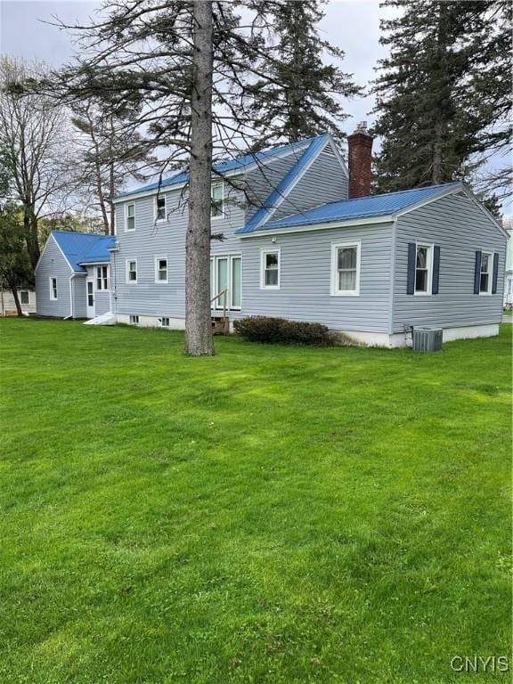 7 Roberts St, Adams, NY 13605 - rear view of house with a chimney, central AC unit, a yard, metal roof, and entry steps
