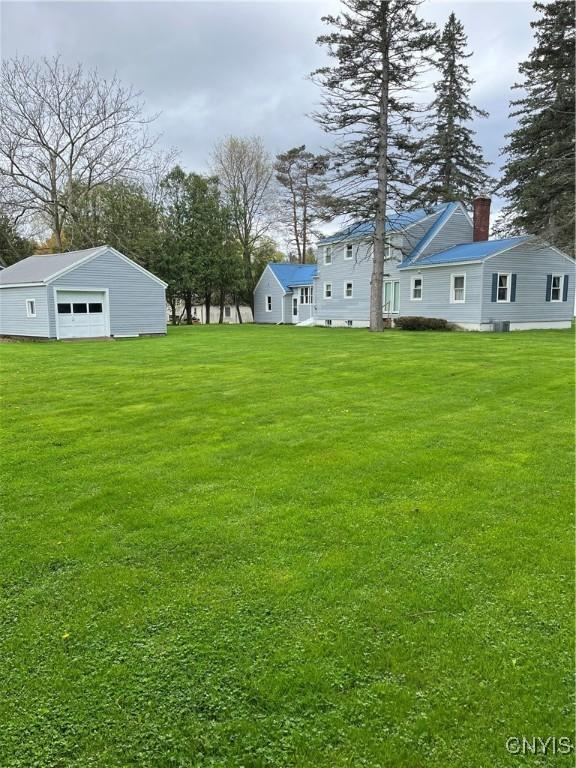 7 Roberts St, Adams, NY 13605 - view of grassy yard featuring a garage and an outbuilding