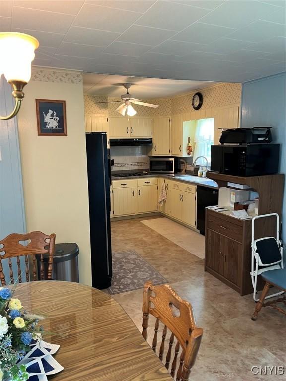 7 Roberts St, Adams, NY 13605 - kitchen featuring black appliances, wallpapered walls, light flooring, range hood, and cream cabinetry