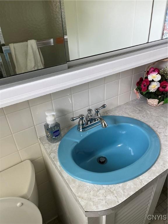 7 Roberts St, Adams, NY 13605 - bathroom view of tasteful backsplash, vanity, and toilet