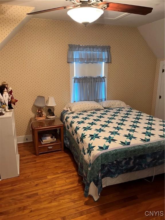 7 Roberts St, Adams, NY 13605 - bedroom featuring wood finished floors, wallpapered walls, ceiling fan, vaulted ceiling, and baseboards