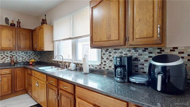 239 Keystone St, Buffalo, NY 14211 - kitchen featuring a sink, brown cabinets, and tasteful backsplash