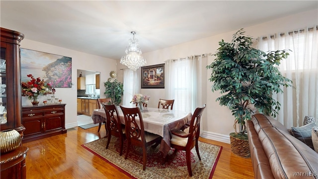239 Keystone St, Buffalo, NY 14211 - dining space with a chandelier, light wood-style flooring, plenty of natural light, and baseboards