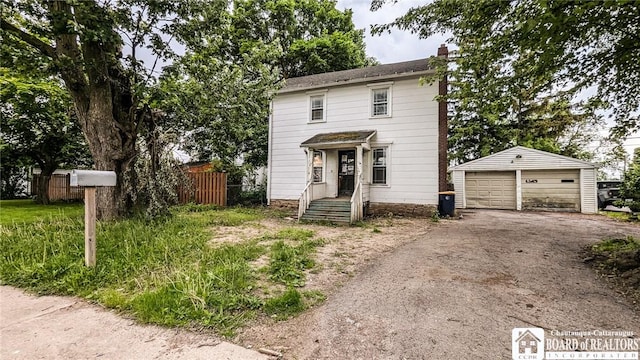 380 Ontario St, Lockport-City, NY 14094 - view of front of house with a garage, an outbuilding, and a chimney