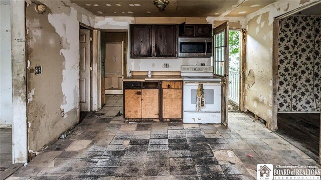 380 Ontario St, Lockport-City, NY 14094 - kitchen with stainless steel microwave, white electric stove, and stone finish floors