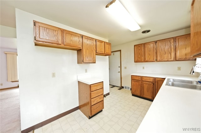 1104 98th St, Niagara Falls, NY 14304 - kitchen featuring a sink, light floors, light countertops, brown cabinetry, and baseboards
