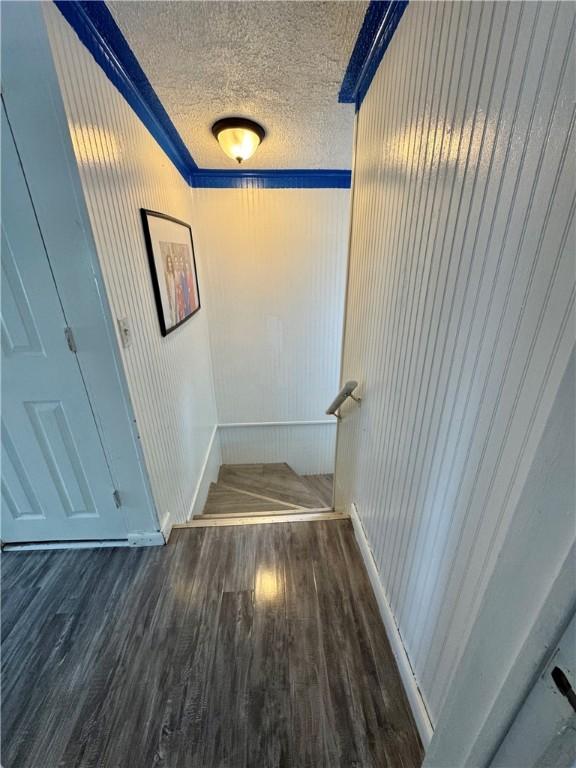 77 Mosley Rd, Greece, NY 14616 - stairway featuring wood finished floors, a textured ceiling, and baseboards