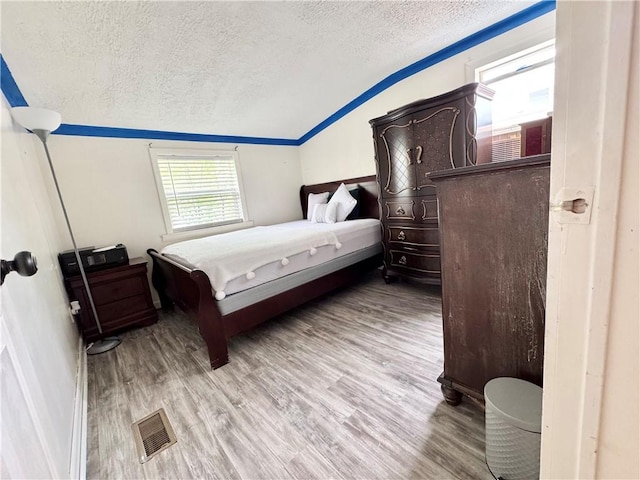 77 Mosley Rd, Greece, NY 14616 - bedroom featuring a textured ceiling, vaulted ceiling, and wood finished floors