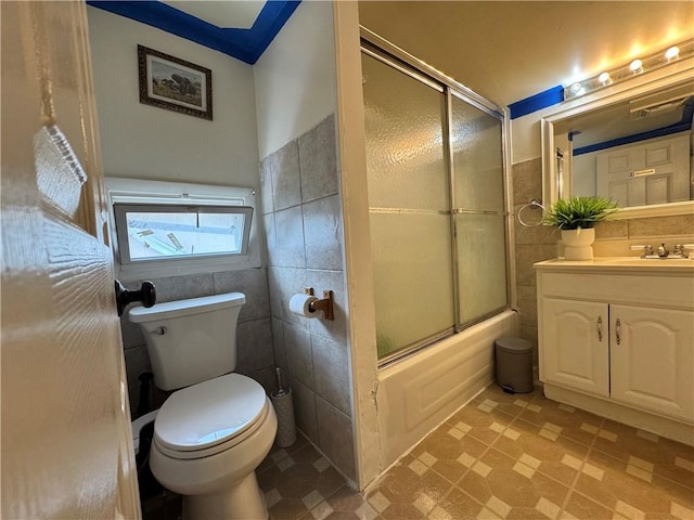 77 Mosley Rd, Greece, NY 14616 - full bathroom featuring tile walls, toilet, vanity, shower / bath combination with glass door, and a wainscoted wall