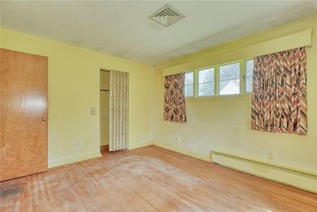 492 Drumm Rd, Webster, NY 14580 - unfurnished bedroom with a baseboard heating unit, wood finished floors, a closet, and baseboards