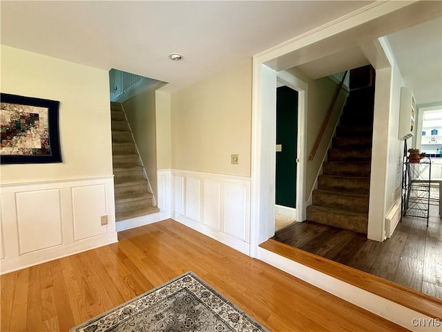 3228 Cedarvale Rd, Onondaga, NY 13120 - stairs featuring wood finished floors, wainscoting, and a decorative wall