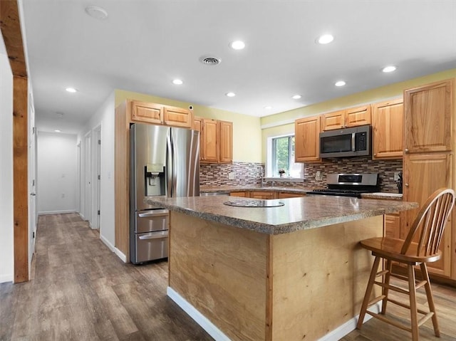 13376 Ridge Rd, Wolcott, NY 14590 - kitchen with stainless steel appliances, a center island, decorative backsplash, dark wood-type flooring, and baseboards