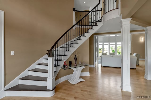 35 Pinegrove Ct, Elma, NY 14059 - stairway featuring decorative columns, wood finished floors, a towering ceiling, baseboards, and ornamental molding
