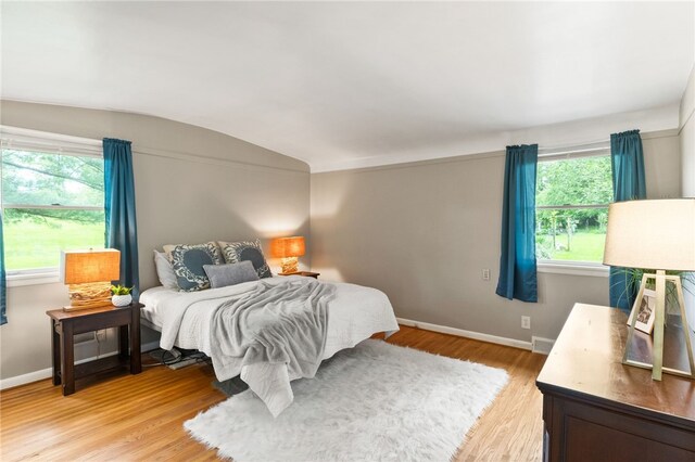 62 E Park Rd, Pittsford, NY 14534 - bedroom featuring vaulted ceiling, light wood-style floors, multiple windows, and baseboards