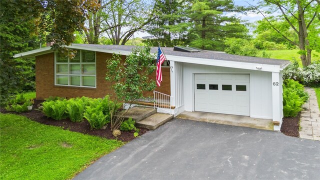 62 E Park Rd, Pittsford, NY 14534 - view of front of property with a detached garage, brick siding, and driveway