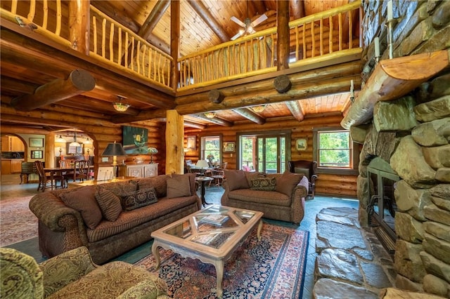1860 Whiskey Creek Rd, Caton, NY 14830 - living area with log walls, a stone fireplace, wooden ceiling with exposed beams, arched walkways, and ceiling fan