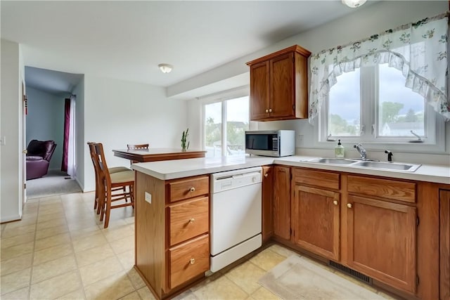 16 Hazel Bark Run, Gates, NY 14606 - kitchen with dishwasher, stainless steel microwave, brown cabinetry, and a peninsula