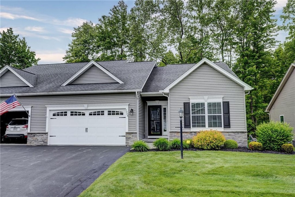 1004 Railway Xing Pvt, Unit Pvt, Webster, NY 14580 - view of front of property featuring a garage, asphalt driveway, a front lawn, roof with shingles, and stone siding