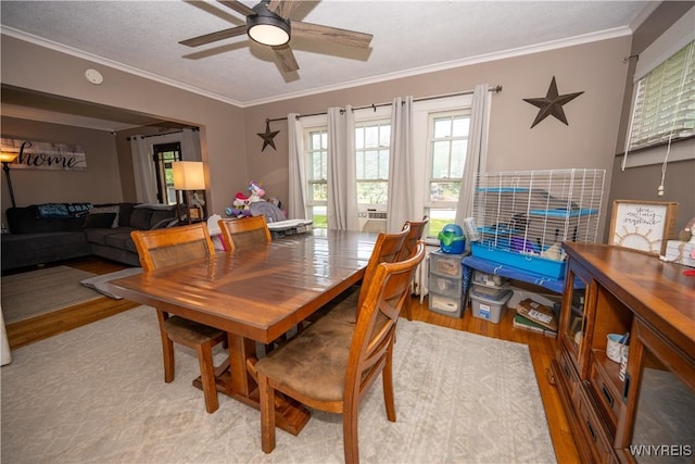 5557 Seneca St, West Seneca, NY 14224 - dining area featuring light wood-type flooring, ornamental molding, and a ceiling fan