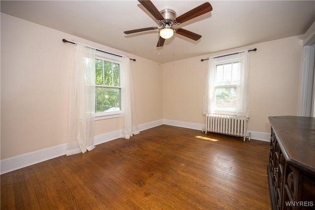 5557 Seneca St, West Seneca, NY 14224 - empty room with radiator, dark wood-style flooring, baseboards, and ceiling fan