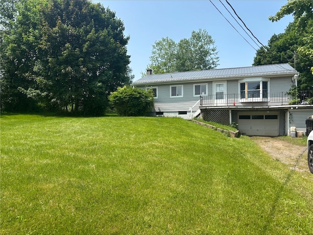 516 County Road 26, Phelps, NY 14513 - view of front facade with a chimney, a garage, a front lawn, and metal roof