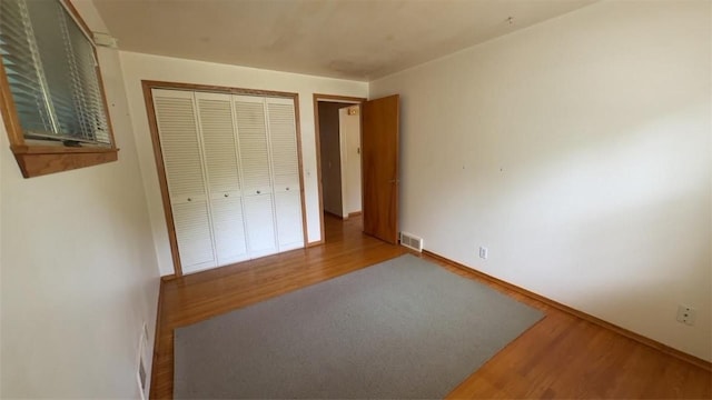 153 Carlisle St, Greece, NY 14615 - unfurnished bedroom with wood finished floors, a closet, and baseboards