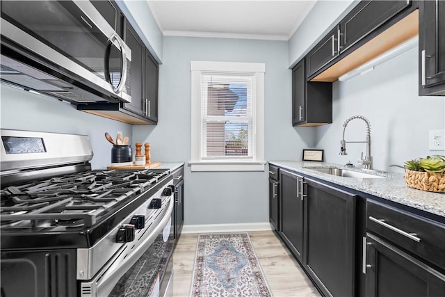 37 Ernestine St, Rochester, NY 14619 - kitchen featuring stainless steel appliances, a sink, dark cabinets, light wood finished floors, and crown molding
