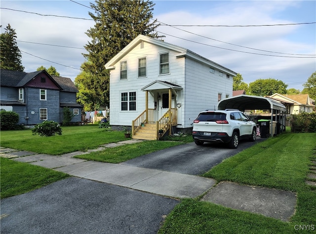 233 Elm St, German Flatts, NY 13357 - traditional-style house featuring a detached carport, asphalt driveway, and a front lawn