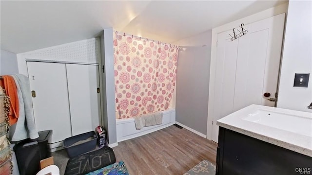233 Elm St, German Flatts, NY 13357 - bathroom featuring wood finished floors, shower / bath combo with shower curtain, vanity, and vaulted ceiling