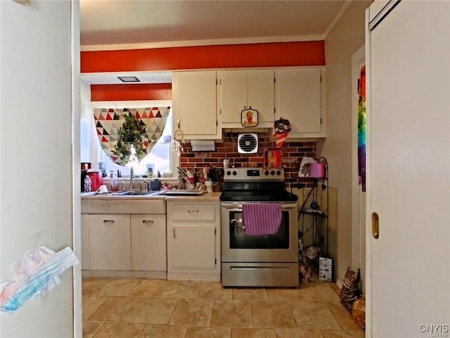 233 Elm St, German Flatts, NY 13357 - kitchen featuring stainless steel range with electric stovetop, a sink, light countertops, tasteful backsplash, and cream cabinetry