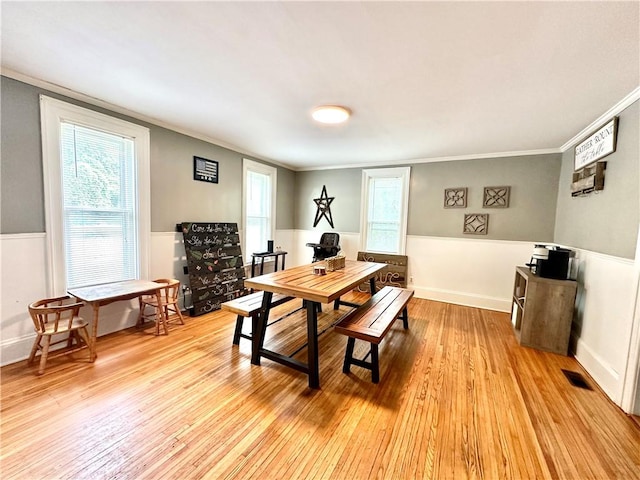 7573 State Route 21, Naples, NY 14512 - dining area featuring ornamental molding, light wood-style flooring, healthy amount of natural light, and wainscoting
