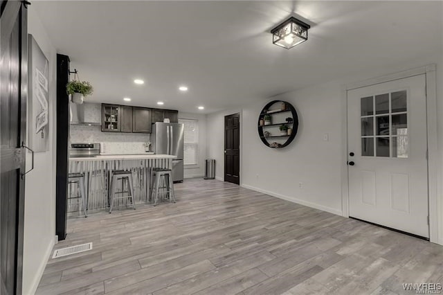 3293 Hartland Rd, Hartland, NY 14067 - kitchen with freestanding refrigerator, a kitchen breakfast bar, stove, light wood-style floors, and baseboards