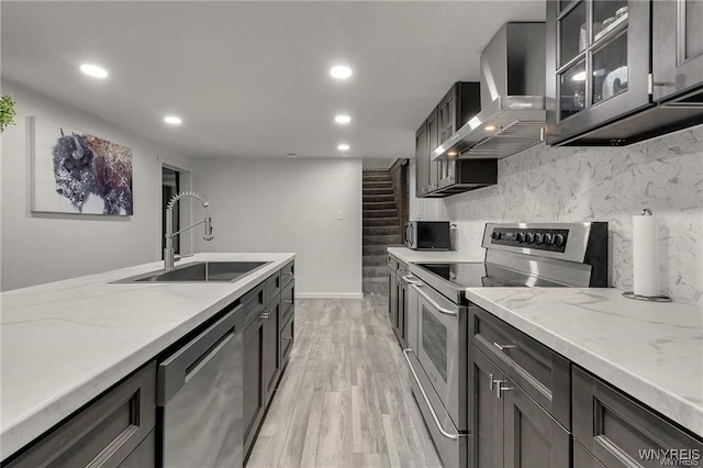 3293 Hartland Rd, Hartland, NY 14067 - kitchen with appliances with stainless steel finishes, wall chimney range hood, a sink, light wood finished floors, and recessed lighting