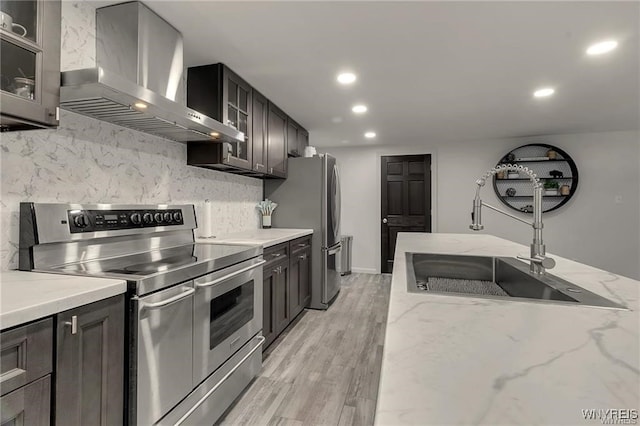 3293 Hartland Rd, Hartland, NY 14067 - kitchen featuring wall chimney exhaust hood, stainless steel appliances, recessed lighting, decorative backsplash, and light wood finished floors