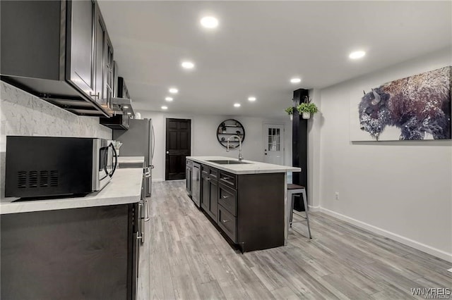 3293 Hartland Rd, Hartland, NY 14067 - kitchen featuring appliances with stainless steel finishes, light countertops, light wood-style floors, recessed lighting, and a center island with sink