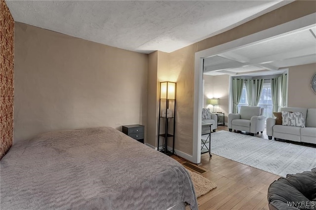 3293 Hartland Rd, Hartland, NY 14067 - bedroom featuring wood-type flooring, coffered ceiling, beamed ceiling, and a textured ceiling