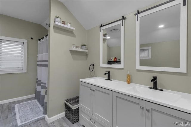 3293 Hartland Rd, Hartland, NY 14067 - full bathroom featuring vaulted ceiling, double vanity, wood finished floors, baseboards, and a shower with shower curtain