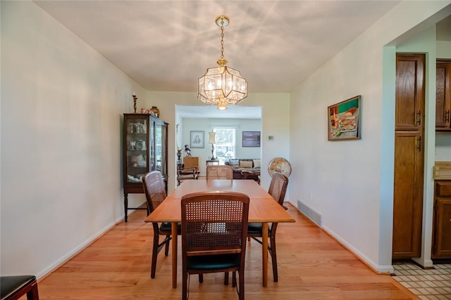 11 Brightwoods Ln, Brighton, NY 14623 - dining space featuring a chandelier, light wood-style flooring, and baseboards