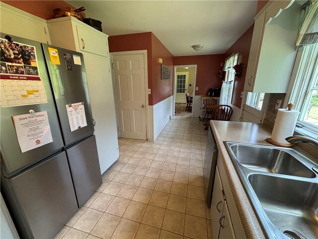 46 Dickerson St, Lyons, NY 14489 - kitchen with a sink, freestanding refrigerator, light tile patterned floors, and wainscoting