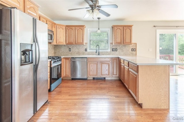 25386 Stewart Dr, Champion, NY 13619 - kitchen with stainless steel appliances, light brown cabinets, a peninsula, light countertops, and light wood-style floors