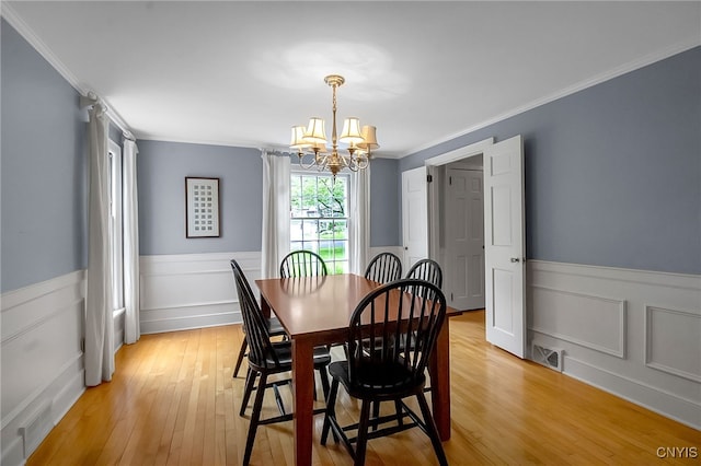 11 S Meadow Dr, Orchard Park, NY 14127 - dining area with a chandelier, ornamental molding, a wainscoted wall, and light wood-style floors