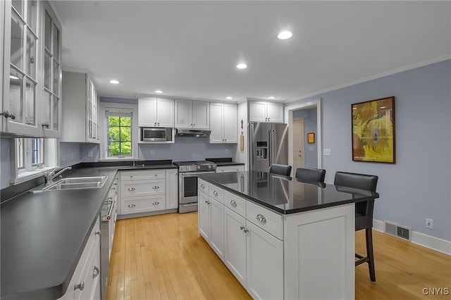 11 S Meadow Dr, Orchard Park, NY 14127 - kitchen featuring stainless steel appliances, under cabinet range hood, a breakfast bar, crown molding, and dark countertops