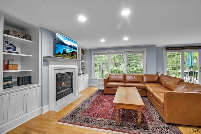 11 S Meadow Dr, Orchard Park, NY 14127 - living area with light wood-style flooring, built in features, a fireplace, recessed lighting, and crown molding